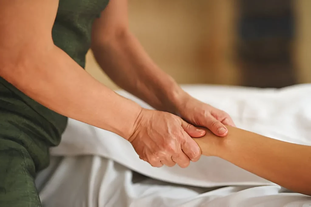 Therapist applying deep medical massage along a patient's back and shoulder